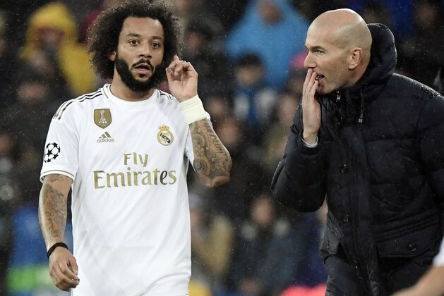 Real Madrid's French coach Zinedine Zidane (R) talks to Real Madrid's Brazilian defender Marcelo during the UEFA Champions League group A football match against Paris Saint-Germain FC at the Santiago Bernabeu stadium in Madrid on November 26, 2019. (Photo by JAVIER SORIANO / AFP) (Photo by JAVIER SORIANO/AFP via Getty Images)