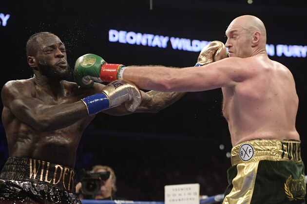 File-This Dec. 1, 2018, file photo shows Deontay Wilder, left, and Tyson Fury, of England, trading punches during a WBC heavyweight championship boxing match in Los Angeles. The WBC heavyweight title rematch between champion Wilder and Fury is off for now. The two fought to a draw in December and were negotiating a rematch. But WBC President Mauricio Sulaiman said Tuesday, Feb. 26, 2019, he received confirmation from Fury that the challenger would look elsewhere for his next bout. (AP Photo/Mark J. Terrill, File)