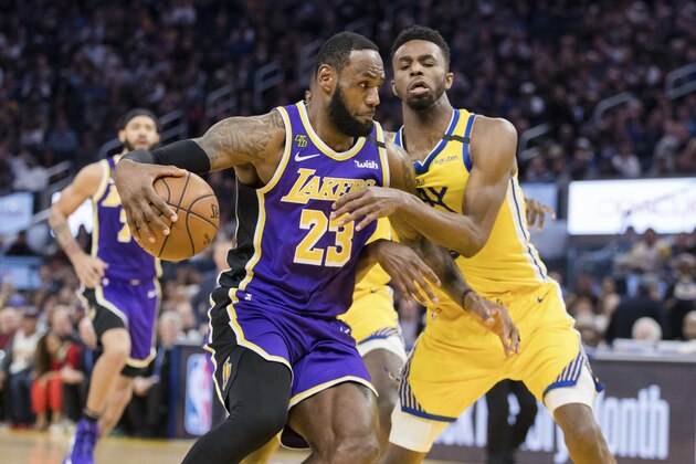 Los Angeles Lakers forward LeBron James (23) drives to the basket as Golden State Warriors guard Andrew Wiggins defends in the first half of an NBA basketball game in San Francisco Saturday, Feb. 8, 2020. (AP Photo/John Hefti)
