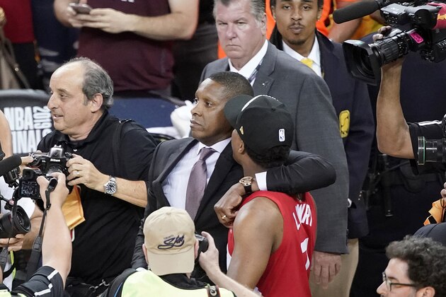 FILE - In this June 13, 2019, file photo, Toronto Raptors President Masai Ujiri, center left, walks with his arm around guard Kyle Lowry after the Raptors defeated the Golden State Warriors in basketball's NBA Finals in Oakland, Calif. On Tuesday, Oct. 22, 2019, the Alameda County District Attorney's Office announced no criminal charges will be filed against Ujiri for an incident involving Ujiri and an Alameda County sheriff's deputy after Game 6 of the finals. (AP Photo/Tony Avelar, File)