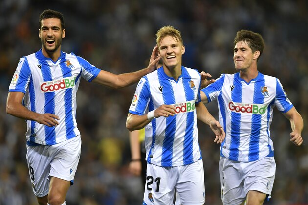 Real Sociedad's Martin Odegaard, center, celebrates with teammates Mikel Merino and Aritz Elustondo, right, after a goal of their team during the Spanish La Liga soccer match between Real Sociedad and Alaves at Reale Arena stadium, in San Sebastian, northern Spain, Thursday, Sept. 26, 2019. (AP Photo/Alvaro Barrientos)