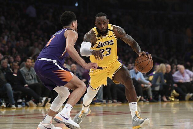 LOS ANGELES, CA - FEBRUARY 10:  LeBron James #23 of the Los Angeles Lakers drives against Devin Booker #1 of the Phoenix Suns during the first half at Staples Center on February 10, 2020 in Los Angeles, California. NOTE TO USER: User expressly acknowledges and agrees that, by downloading and/or using this Photograph, user is consenting to the terms and conditions of the Getty Images License Agreement. (Photo by Kevork Djansezian/Getty Images)