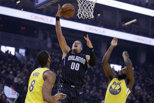 Orlando Magic's Aaron Gordon (00) lays up a shot between Golden State Warriors' Alec Burks,left, and Eric Paschall, right, during the first half of an NBA basketball game Saturday, Jan. 18, 2020, in San Francisco. (AP Photo/Ben Margot)