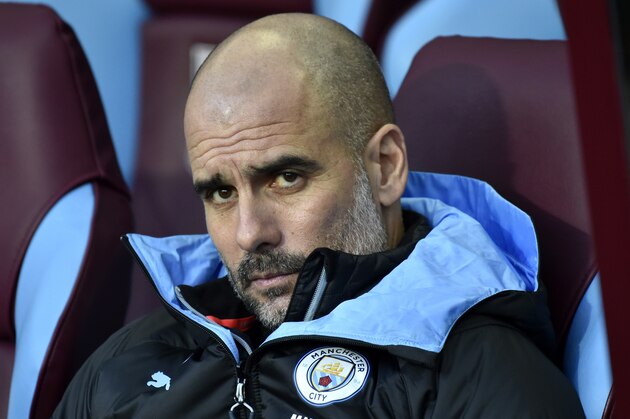 Manchester City's head coach Pep Guardiola looks out from the bench during warmup before the English Premier League soccer match between Aston Villa and Manchester City at Villa Park in Birmingham, England, Sunday, Jan. 12, 2020. (AP Photo/Rui Vieira)