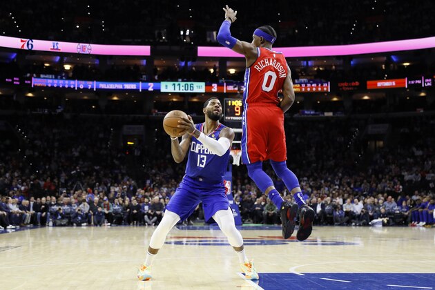 Los Angeles Clippers' Paul George, left, tries to get a shot past Philadelphia 76ers' Josh Richardson during the first half of an NBA basketball game, Tuesday, Feb. 11, 2020, in Philadelphia. (AP Photo/Matt Slocum)
