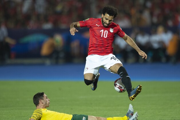 CAIRO, EGYPT - JULY 06: Mohamed Salah of Egypt jumps a tackle from Dean Furman of South Africa during the 2019 Africa Cup of Nations Round of 16 match between Egypt and South Africa at Cairo International Stadium on July 6, 2019 in Cairo, Egypt. (Photo by Visionhaus) CAIRO, EGYPT - JULY 06: Mohamed Salah of Egypt jumps a tackle from Dean Furman of South Africa during the 2019 Africa Cup of Nations Round of 16 match between Egypt and South Africa at Cairo International Stadium on July 6, 2019 in Cairo, Egypt. (Photo by Visionhaus)