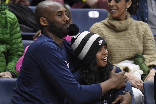 FILE - In this March 2, 2019, file photo Kobe Bryant and his daughter Gianna watch the first half of an NCAA college basketball game between Connecticut and Houston in Storrs, Conn. A public memorial service for Bryant, Gianna and seven others killed in a helicopter crash is planned for Monday, Feb. 24, 2020, at Staples Center in Los Angeles, a person with knowledge of the details told The Associated Press on Thursday, Feb. 6, 2020. (AP Photo/Jessica Hill, File)
