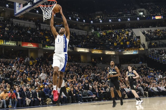 Indiana Pacers forward T.J. Warren dunks in front of Milwaukee Bucks defenders Khris Middleton, center, and Ersan Ilyasova during the first half of an NBA basketball game in Indianapolis, Wednesday, Feb. 12, 2020. (AP Photo/AJ Mast)