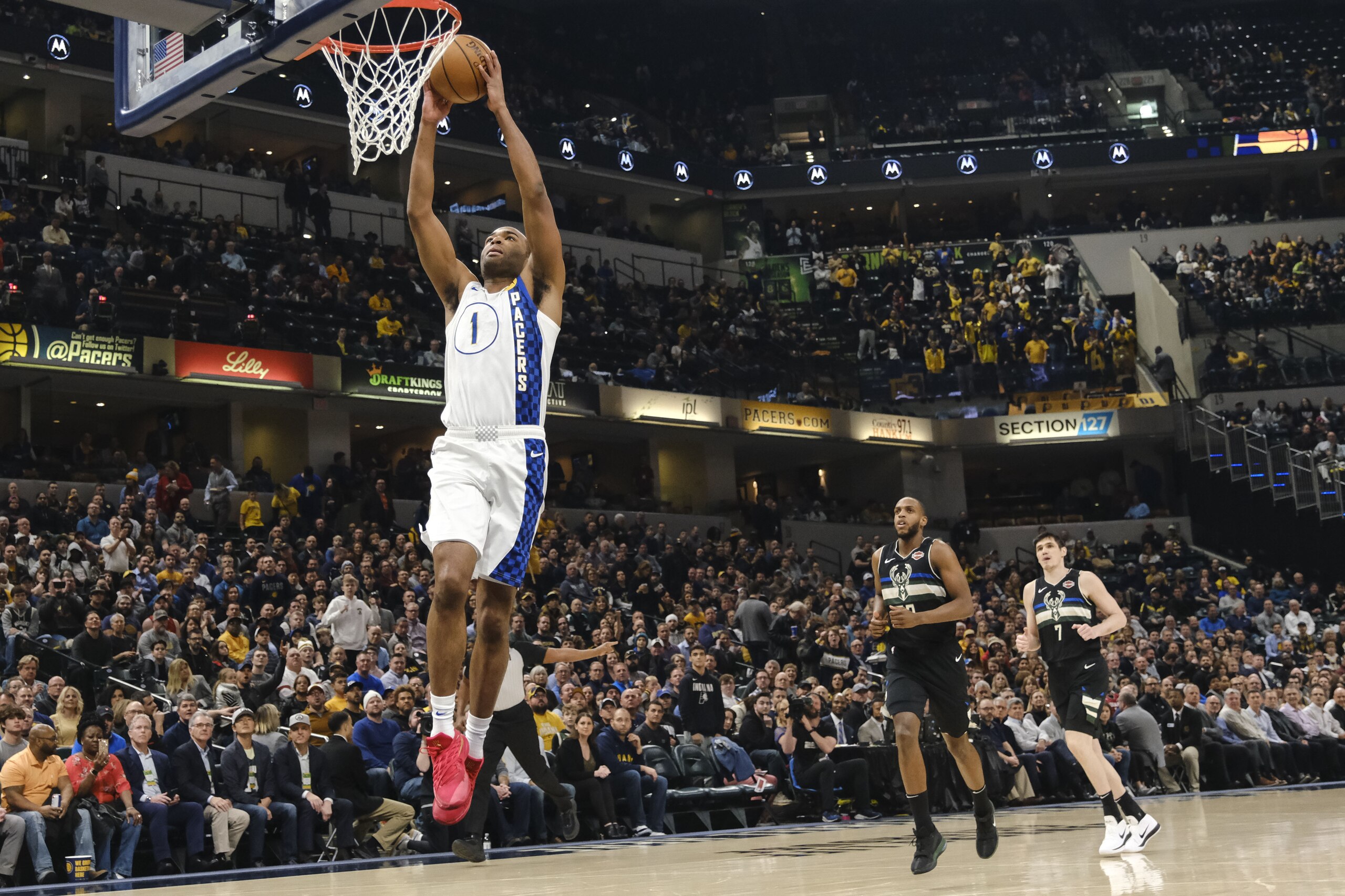 Indiana Pacers forward T.J. Warren dunks in front of Milwaukee Bucks defenders Khris Middleton, center, and Ersan Ilyasova during the first half of an NBA basketball game in Indianapolis, Wednesday, Feb. 12, 2020. (AP Photo/AJ Mast)