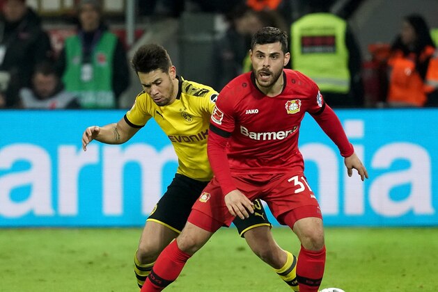 LEVERKUSEN, GERMANY - FEBRUARY 08: (BILD ZEITUNG OUT) Raphael Guerreiro of Borussia Dortmund and Kevin Volland of Bayer 04 Leverkusen during the Bundesliga match between Bayer 04 Leverkusen and Borussia Dortmund at BayArena on February 8, 2020 in Leverkusen, Germany. (Photo by TF-Images/Getty Images)