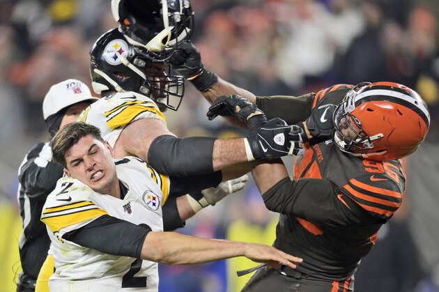Cleveland Browns defensive end Myles Garrett (95) hits Pittsburgh Steelers quarterback Mason Rudolph (2) with a helmet during the second half of an NFL football game Thursday, Nov. 14, 2019, in Cleveland. (AP Photo/David Richard)