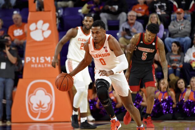 Clemson's Clyde Trapp, center, dribbles after a steal during the first half of an NCAA college basketball game against Louisville, Saturday, Feb. 15, 2020, in Clemson, S.C. (AP Photo/Richard Shiro) Clemson's Clyde Trapp, center, dribbles after a steal during the first half of an NCAA college basketball game against Louisville, Saturday, Feb. 15, 2020, in Clemson, S.C. (AP Photo/Richard Shiro)