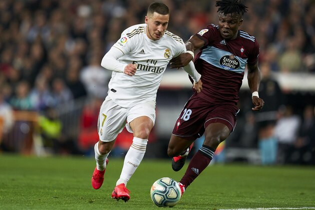 MADRID, SPAIN - FEBRUARY 16: Eden Hazard of Real Madrid competes for the ball with Aidoo of Celta de Vigo during the Liga match between Real Madrid CF and RC Celta de Vigo at Estadio Santiago Bernabeu on February 16, 2020 in Madrid, Spain. (Photo by Mateo Villalba/Quality Sport Images/Getty Images)