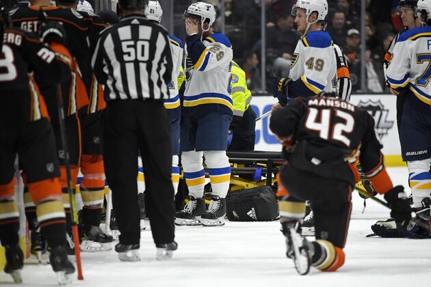 St. Louis Blues defenseman Vince Dunn, left, of center wipes his faces as Anaheim Ducks defenseman Josh Manson kneels on the ice while blues defenseman Jay Bouwmeester, who suffered a medical emergency, is worked on by medical personnel during the first period of an NHL hockey game Tuesday, Feb. 11, 2020, in Anaheim, Calif. (AP Photo/Mark J. Terrill) St. Louis Blues defenseman Vince Dunn, left, of center wipes his faces as Anaheim Ducks defenseman Josh Manson kneels on the ice while blues defenseman Jay Bouwmeester, who suffered a medical emergency, is worked on by medical personnel during the first period of an NHL hockey game Tuesday, Feb. 11, 2020, in Anaheim, Calif. (AP Photo/Mark J. Terrill)