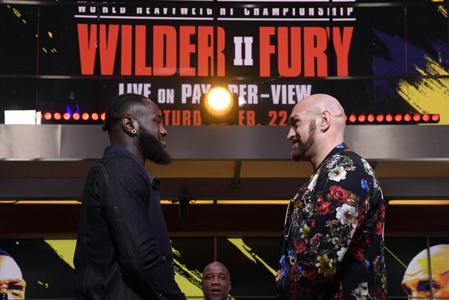 LOS ANGELES, CA - JANUARY 25: Deontay Wilder (L) and Tyson Fury face off with sportscaster Curt Menefee looking on during a news conference at Fox Studios on January 25, 2020 in Los Angeles, California. (Photo by Kevork Djansezian/Getty Images)