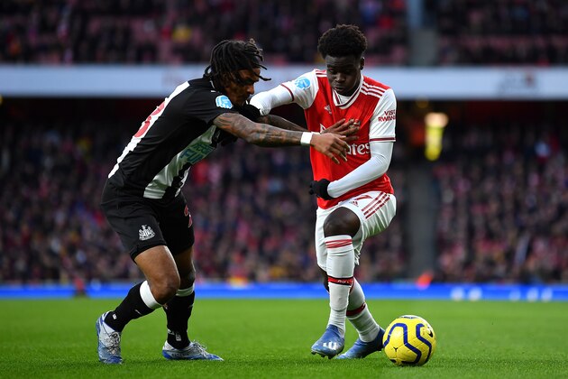 LONDON, ENGLAND - FEBRUARY 16: Bukayo Saka of Arsenal takes on Valentino Lazaro of Newcastle United during the Premier League match between Arsenal FC and Newcastle United at Emirates Stadium on February 16, 2020 in London, United Kingdom. (Photo by Justin Setterfield/Getty Images)