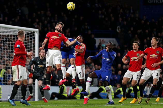 Manchester United's Portuguese midfielder Bruno Fernandes (C) jumps to win a header during the English Premier League football match between Chelsea and Manchester United at Stamford Bridge in London on February 17, 2020. - Manchester United won the game 2-0. (Photo by Adrian DENNIS / AFP) / RESTRICTED TO EDITORIAL USE. No use with unauthorized audio, video, data, fixture lists, club/league logos or 'live' services. Online in-match use limited to 120 images. An additional 40 images may be used in extra time. No video emulation. Social media in-match use limited to 120 images. An additional 40 images may be used in extra time. No use in betting publications, games or single club/league/player publications. /  (Photo by ADRIAN DENNIS/AFP via Getty Images)