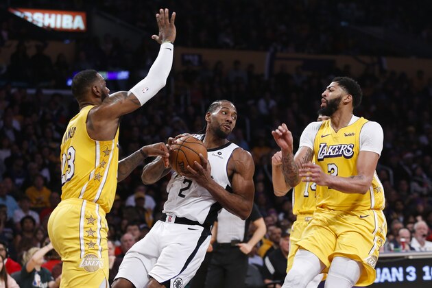 Los Angeles Clippers' Kawhi Leonard (2) looks to pass the ball against Los Angeles Lakers' LeBron James (23) and Los Angeles Lakers' Anthony Davis (3) during an NBA basketball game between Los Angeles Lakers and Los Angeles Clippers, Wednesday, Dec. 25, 2019, in Los Angeles. The Clippers won 111-106. (AP Photo/Ringo H.W. Chiu)