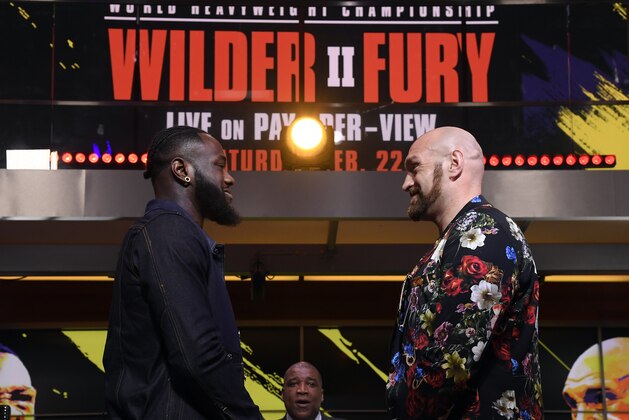 LOS ANGELES, CA - JANUARY 25: Deontay Wilder (L) and Tyson Fury face off with sportscaster Curt Menefee looking on during a news conference at Fox Studios on January 25, 2020 in Los Angeles, California. (Photo by Kevork Djansezian/Getty Images)