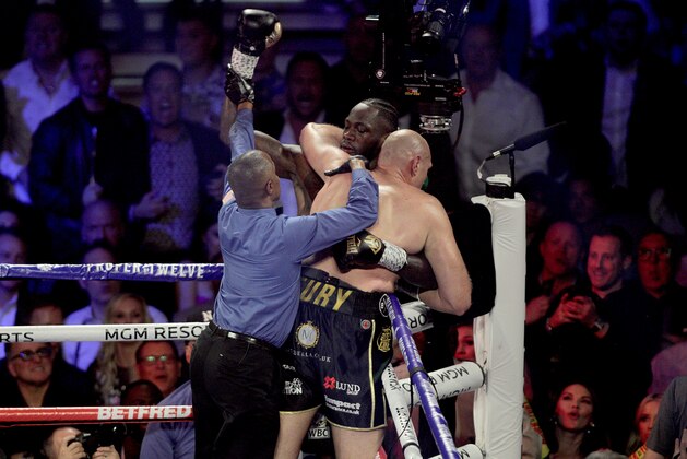 The referee breaks up British boxer Tyson Fury (R) and US boxer Deontay Wilder after clinching in the corner during their World Boxing Council (WBC) Heavyweight Championship Title boxing match at the MGM Grand Garden Arena in Las Vegas on February 22, 2020. (Photo by John Gurzinski / AFP) (Photo by JOHN GURZINSKI/AFP via Getty Images)