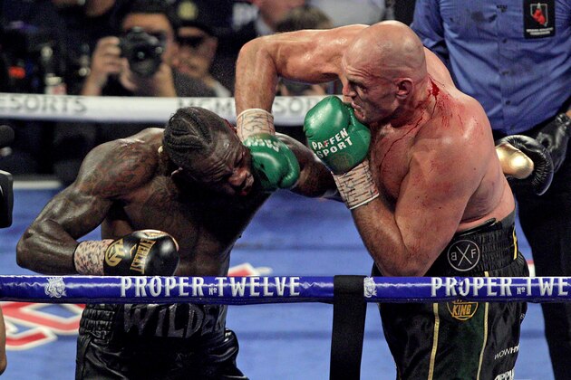 British boxer Tyson Fury (R) slams a right to the head of US boxer Deontay Wilder during their World Boxing Council (WBC) Heavyweight Championship Title boxing match at the MGM Grand Garden Arena in Las Vegas on February 22, 2020. (Photo by John Gurzinski / AFP) (Photo by JOHN GURZINSKI/AFP via Getty Images)