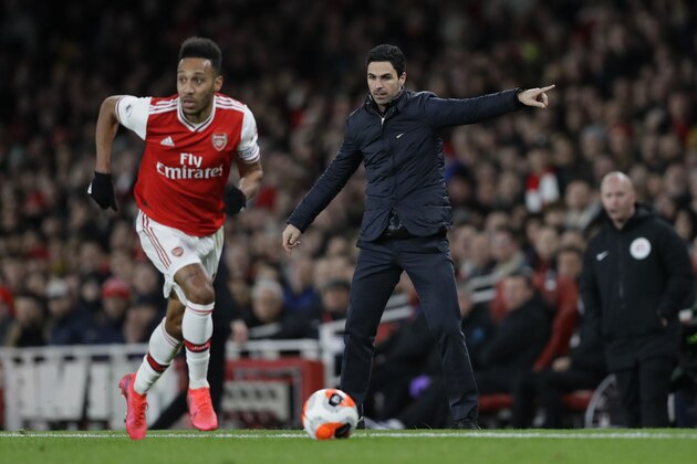 Arsenal's head coach Mikel Arteta, right, gives instructions from the side line as Arsenal's Pierre-Emerick Aubameyang runs with the ball during the English Premier League soccer match between Arsenal and Everton at Emirates stadium in London, Sunday, Feb. 23, 2020. (AP Photo/Kirsty Wigglesworth)