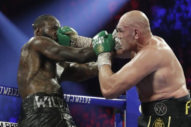 Tyson Fury, of England, lands a right to Deontay Wilder during a WBC heavyweight championship boxing match Saturday, Feb. 22, 2020, in Las Vegas. (AP Photo/Isaac Brekken)