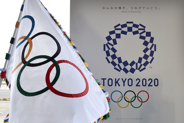The Olympic flag (L) and the logo of the Tokyo 2020 are displayed during the official flag arrival ceremony at the Tokyo's Haneda airport on August 24, 2016. - The Olympic flag arrived in Tokyo on August 24, as Japan's capital gears up to host the 2020 Games, with officials promising smooth sailing after Rio's sometimes shaky 2016 instalment. (Photo by KAZUHIRO NOGI / AFP)        (Photo credit should read KAZUHIRO NOGI/AFP via Getty Images)