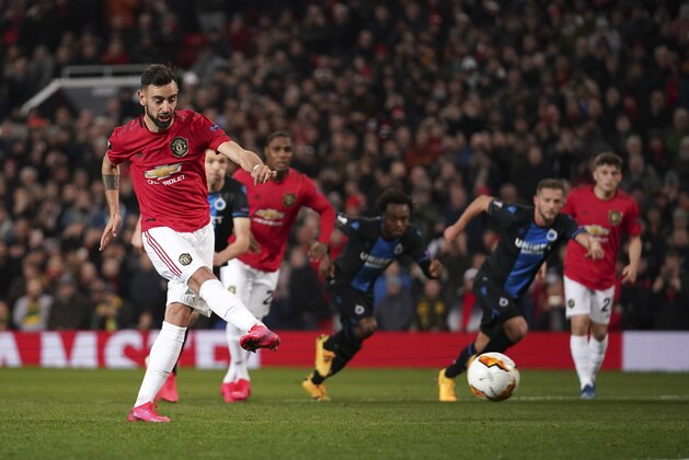 Manchester United's Bruno Fernandes, left, scores his side's opening goal from the penalty spot during the round of 32 second leg Europa League soccer match between Manchester United and Brugge at Old Trafford in Manchester, England, Thursday, Feb. 27, 2020. (AP Photo/Dave Thompson)