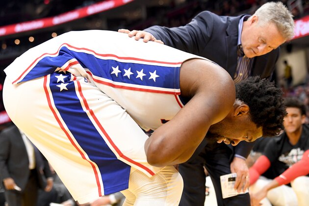 CLEVELAND, OHIO - FEBRUARY 26: Head coach Brett Brown checks on Joel Embiid #21 of the Philadelphia 76ers after Embiid suffered an injury during the first half against the Cleveland Cavaliers at Rocket Mortgage Fieldhouse on February 26, 2020 in Cleveland, Ohio. NOTE TO USER: User expressly acknowledges and agrees that, by downloading and/or using this photograph, user is consenting to the terms and conditions of the Getty Images License Agreement. (Photo by Jason Miller/Getty Images)