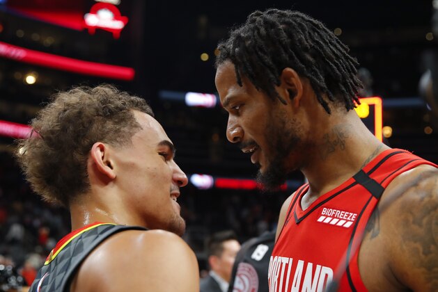 ATLANTA, GA - FEBRUARY 29: Trae Young #11 of the Atlanta Hawks and Trevor Ariza #8 of the Portland Trail Blazers hug it out at the conclusion of an NBA game at State Farm Arena on February 29, 2020 in Atlanta, Georgia. NOTE TO USER: User expressly acknowledges and agrees that, by downloading and/or using this photograph, user is consenting to the terms and conditions of the Getty Images License Agreement. (Photo by Todd Kirkland/Getty Images)