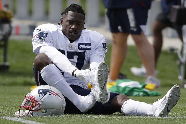 FILE - In this Wednesday, Sept. 18, 2019, file photo, New England Patriots wide receiver Antonio Brown puts on his  Nike cleats during NFL football practice in Foxborough, Mass. Nike has dropped Brown, Nike spokesman Josh Benedek told The Associated Press on Friday, Sept. 20, 2019. The move comes after a second woman accused Brown of sexual assault.   (AP Photo/Steven Senne, File)
