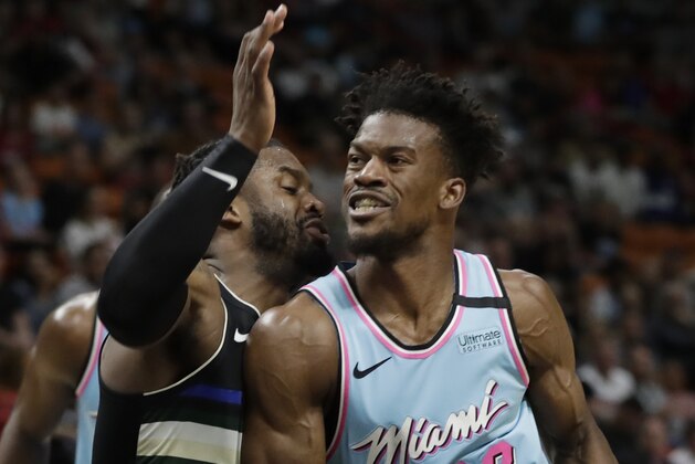Miami Heat forward Jimmy Butler (22) drives to the basket against Milwaukee Bucks guard Wesley Matthews during the first half of an NBA basketball game, Monday, March 2, 2020, in Miami. (AP Photo/Wilfredo Lee)