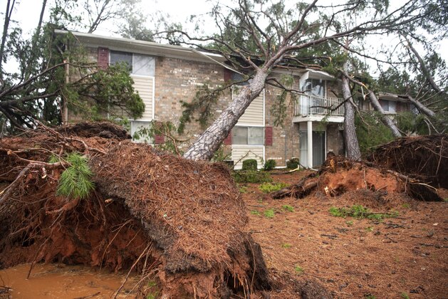 CORRECTS YEAR TO 2020 NOT 2019 - Fallen trees rest on the roof of an apartment complex damaged by a reported tornado Thursday, Feb. 6, 2020, in Spartanburg, S.C. A powerful winter storm brought severe weather across the Deep South early Thursday, with high winds causing damage that killed one person, injured several others and littered at least four states. (AP Photo/Sean Rayford)
