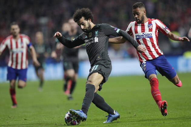 Liverpool's Mohamed Salah, left, challenges for the ball with Atletico Madrid's Renan Lodi during a first leg, round of 16, Champions League soccer match between Atletico Madrid and Liverpool at the Wanda Metropolitano stadium in Madrid, Spain, Tuesday Feb. 18, 2020. (AP Photo/Bernat Armangue)