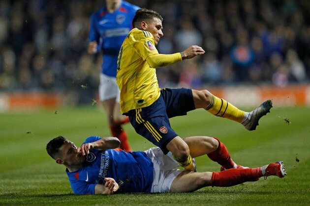Portsmouth's English defender James Bolton (L) challenges Arsenal's Uruguayan midfielder Lucas Torreira (R) resulting in an injury for Torreira during the English FA Cup fifth round football match between Portsmouth and Arsenal at Fratton Park stadium in Portsmouth, southern England, on March 2, 2020. (Photo by Adrian DENNIS / AFP) / RESTRICTED TO EDITORIAL USE. No use with unauthorized audio, video, data, fixture lists, club/league logos or 'live' services. Online in-match use limited to 120 images. An additional 40 images may be used in extra time. No video emulation. Social media in-match use limited to 120 images. An additional 40 images may be used in extra time. No use in betting publications, games or single club/league/player publications. /  (Photo by ADRIAN DENNIS/AFP via Getty Images)