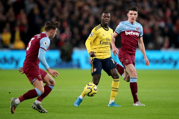 LONDON, ENGLAND - DECEMBER 09: Nicolas Pepe of Arsenal in action with Aaron Cresswell and Declan Rice of West Ham United during the Premier League match between West Ham United and Arsenal FC at London Stadium on December 9, 2019 in London, United Kingdom. (Photo by Marc Atkins/Getty Images)