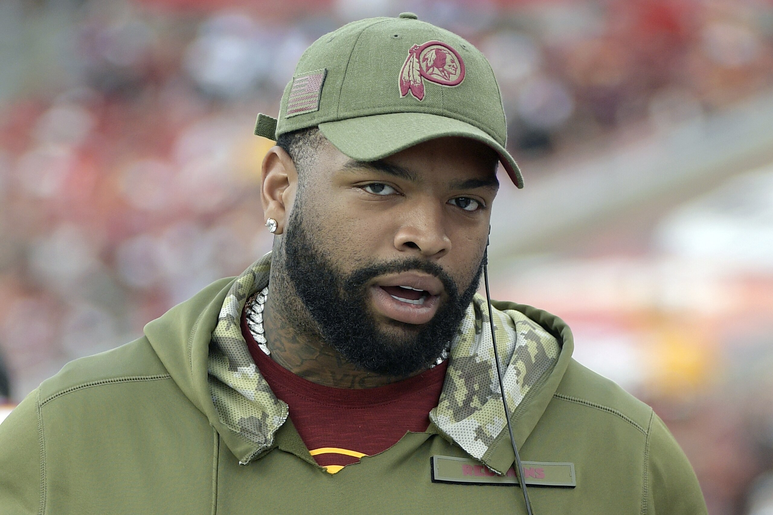 FILE - In this Nov. 11, 2018, file photo, Washington Redskins offensive tackle Trent Williams stands on the sideline during the second half of an NFL football game against the Tampa Bay Buccaneers in Tampa, Fla. A person with knowledge of the situation says Williams has reported to the Redskins, ending his holdout. The person spoke to The Associated Press on condition of anonymity on Tuesday, Oct. 29, 2019, because the team had not announced Williams’ return. He can be kept off the 53-man roster for up to three weeks after reporting.(AP Photo/Phelan M. Ebenhack, File)