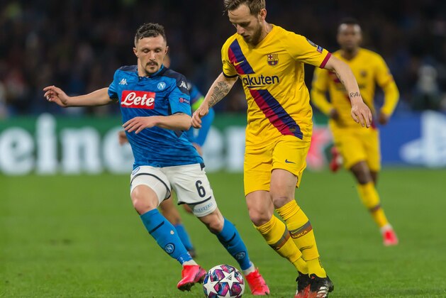 NAPLES, ITALY - FEBRUARY 25: (BILD ZEITUNG OUT) Mario Rui of SSC Neapel and Ivan Rakitic of FC Barcelona battle for the ball during the UEFA Champions League round of 16 first leg match between SSC Napoli and FC Barcelona at Stadio San Paolo on February 25, 2020 in Naples, Italy. (Photo by Harry Langer/DeFodi Images via Getty Images)