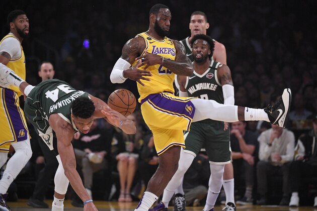 Milwaukee Bucks forward Giannis Antetokounmpo, second from left, and Los Angeles Lakers forward LeBron James collide during the first half of an NBA basketball game Friday, March 6, 2020, in Los Angeles. (AP Photo/Mark J. Terrill)