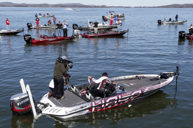 Randall Tharp, Port Saint Joe, Fla., holds up a bass for spectators following him on the second day of the Bassmaster Classic, Saturday, Feb. 22, 2014, in Guntersville, Ala. Tharp was bumped from first to second by 1 ounce by Edwin Evers, Talala, Okla. The field will be cut to the top 25 anglers for the final day of competition. (AP Photo/Hal Yeager)