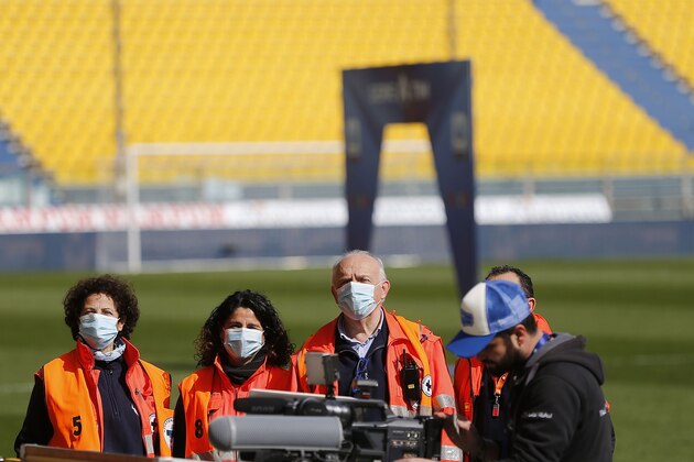 PARMA, ITALY - MARCH 08: People stand on the pitch wearing face masks during the Serie A match between Parma Calcio and SPAL at Stadio Ennio Tardini on March 8, 2020 in Parma, Italy. The match was delayed due to concerns over the outbreak of the coronavirus in the country.  (Photo by Gabriele Maltinti/Getty Images)