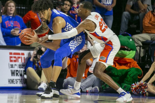 Kentucky forward Nick Richards (4) steals the ball from Florida guard Scottie Lewis (23) during the second half of an NCAA college basketball game Saturday, March 7, 2020, in Gainesville, Fla. (AP Photo/Alan Youngblood)