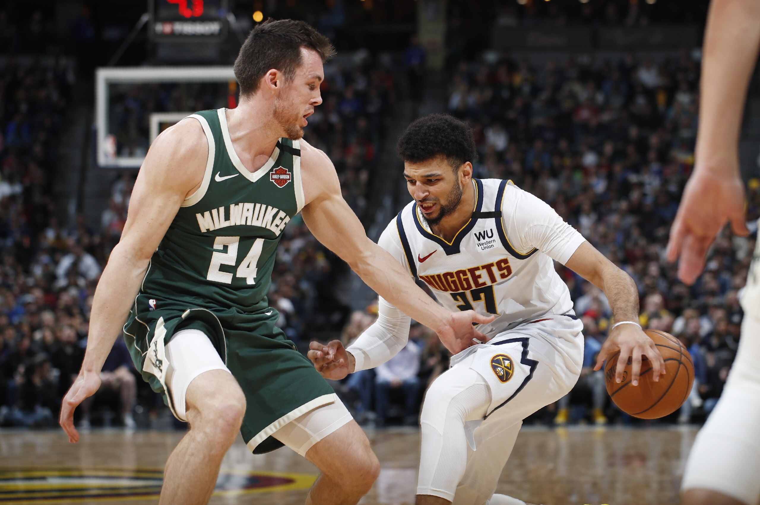 Denver Nuggets guard Jamal Murray, right, drives to the basket as Milwaukee Bucks guard Pat Connaughton defends in the first half of an NBA basketball game Monday, March 9, 2020, in Denver. (AP Photo/David Zalubowski)