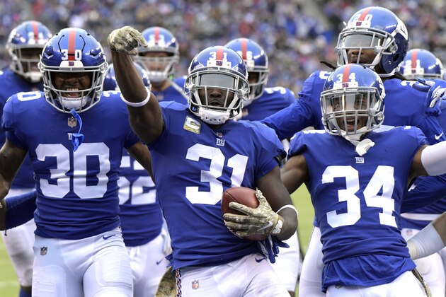 FILE - In this Nov. 18, 2018, file photo, New York Giants' Michael Thomas, center, celebrates an interception with his teammates during the first half of an NFL football game against the Tampa Bay Buccaneers in East Rutherford, N.J.  Guaranteed payments for unrestricted free-agent contracts this month make up just over half of the total money to be paid, down a bit from 2018. “Obviously we are trying to figure how to improve that to 100 percent,” says Giants safety Michael Thomas, a member of the NFLPA’s executive committee. (AP Photo/Bill Kostroun, File)