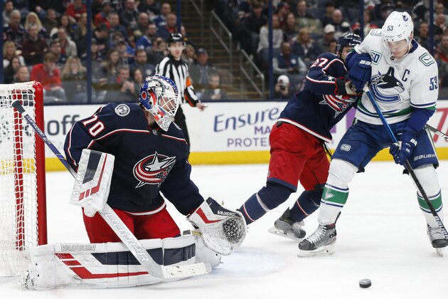 Columbus Blue Jackets' Joonas Korpisalo, left, of Finland, makes a save as teammate Ryan Murray, center, and Vancouver Canucks' Bo Horvat fight for position during the third period of an NHL hockey game Sunday, March 1, 2020, in Columbus, Ohio. The Blue Jackets defeated the Canucks 5-3. (AP Photo/Jay LaPrete)
