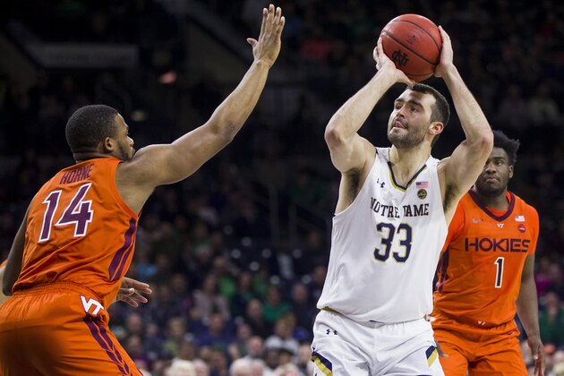 Notre Dame's John Mooney (33) takes a shot with pressure from Virginia Tech's P.J. Horne (14) during the second half of an NCAA college basketball game Saturday, March 7, 2020, in South Bend, Ind. Notre Dame won 64-56. (AP Photo/Robert Franklin)