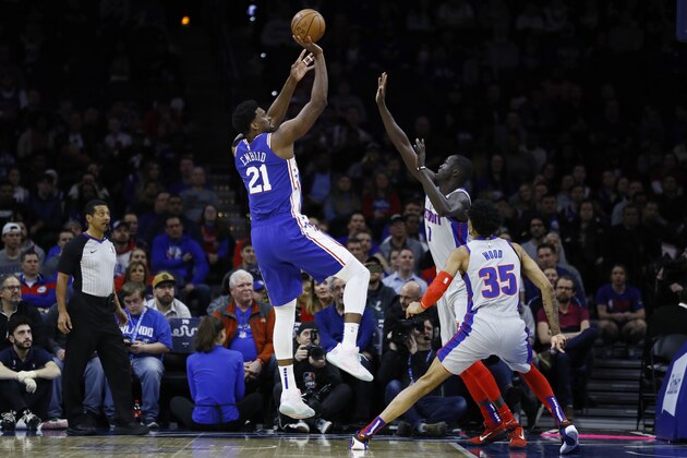 Philadelphia 76ers' Joel Embiid (21) goes up for a shot against Detroit Pistons' Thon Maker (7) and Christian Wood (35) during the first half of an NBA basketball game, Wednesday, March 11, 2020, in Philadelphia. (AP Photo/Matt Slocum)