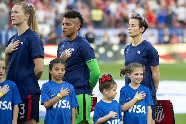 United States midfielder Samantha Mewis (3), goalkeeper Adrianna Franch, center, and forward Megan Rapinoe, right, stand with their jerseys turned inside out during the playing of the national anthem before a SheBelieves Cup women's soccer match against Japan, Wednesday, March 11, 2020 at Toyota Stadium in Frisco, Texas. (AP Photo/Jeffrey McWhorter)
