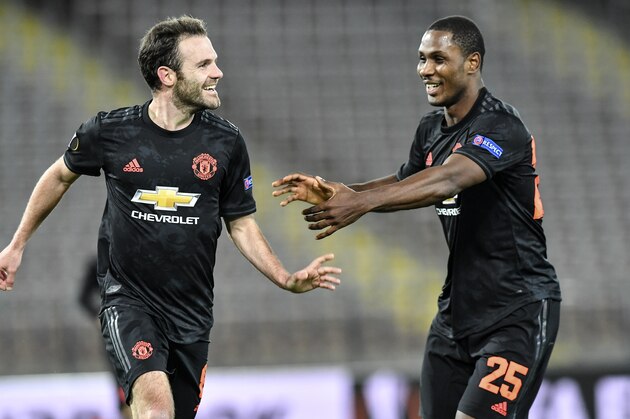 Manchester United's Juan Mata, left, celebrates after scoring his side's third goal with Manchester United's Odion Ighalo, right, during the Europa League round of 16 first leg soccer match between Linzer ASK and Manchester United in Linz, Austria, Thursday, March 12, 2020. The match is being played in an empty stadium because of the coronavirus outbreak. (AP Photo/Kerstin Joensson)